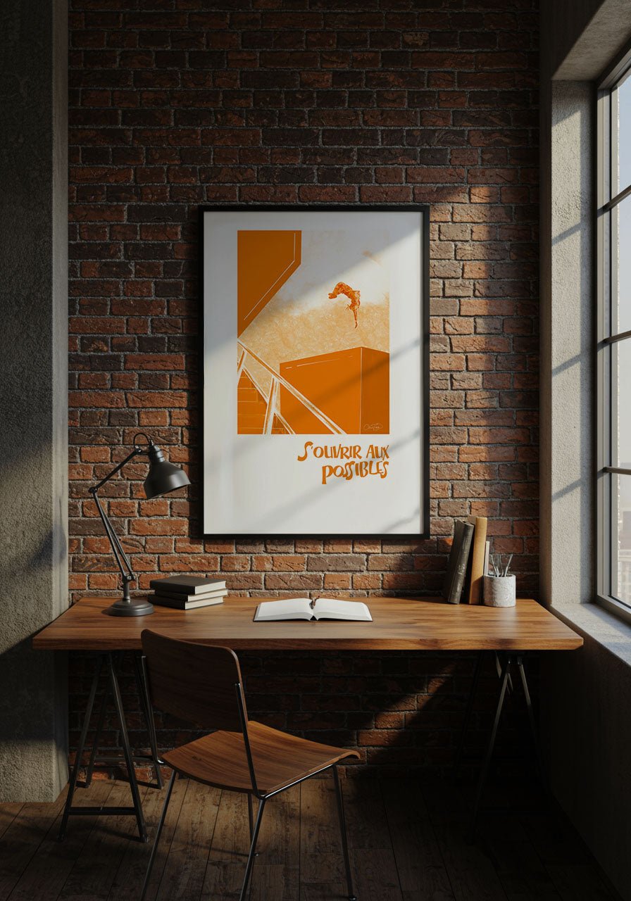 Affiche “S’ouvrir aux possibles” accrochée sur un mur en briques au-dessus d’un bureau en bois avec lampe de travail.