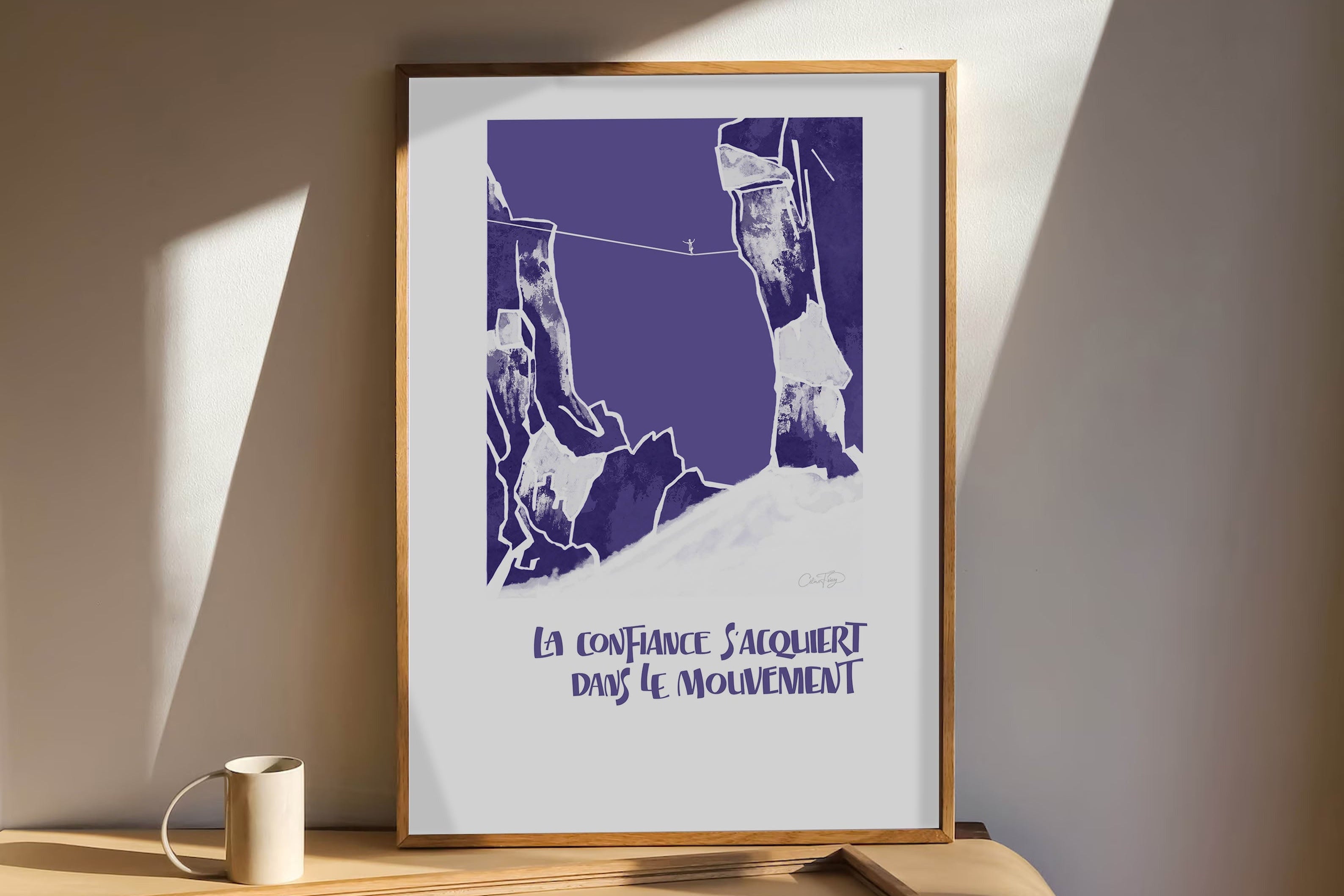 Affiche orange “S’ouvrir aux possibles” posée sur un bureau en bois avec éléments décoratifs naturels.