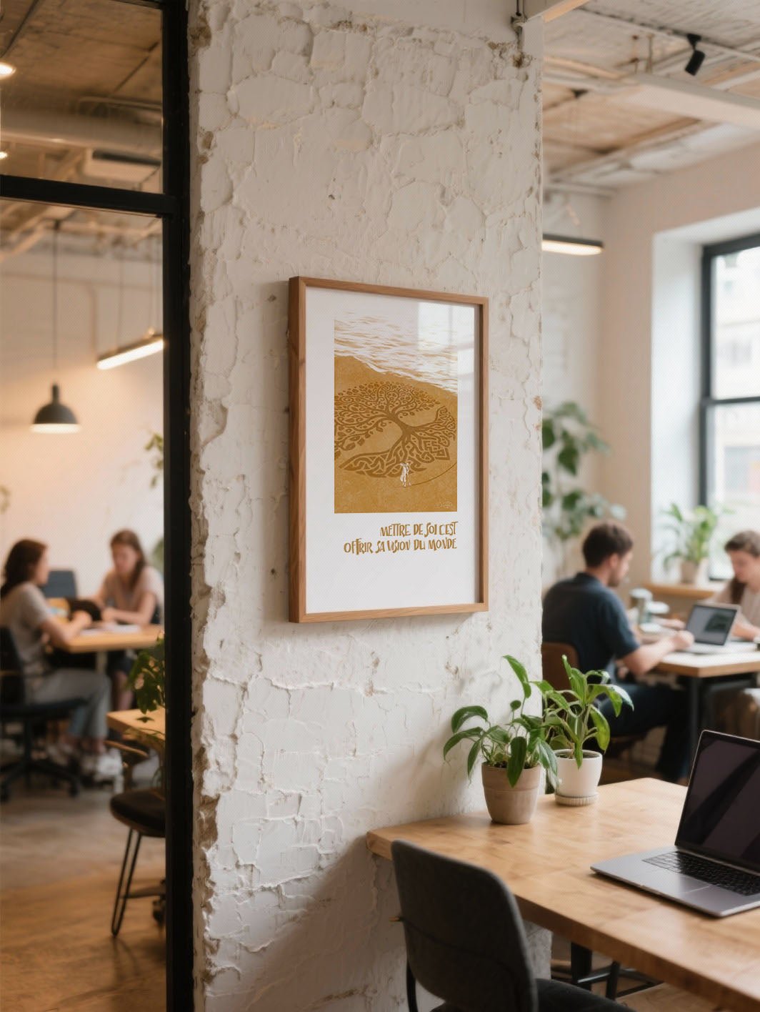 Affiche dorée “Mettre de soi, c’est offrir sa vision du monde” accrochée sur un mur texturé dans un espace de coworking chaleureux.